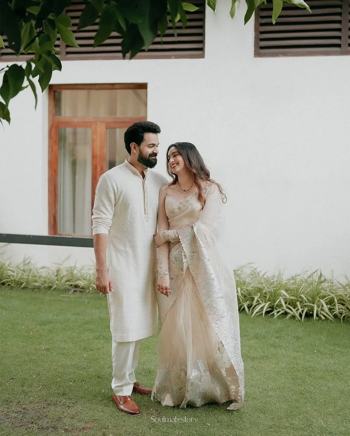 A couple walking together outside a bright modern home
